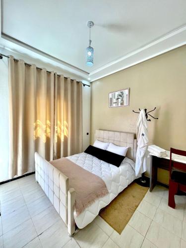 拉希迪耶hotel darna with air conditioning的卧室里有一张白色的大床和一张书桌