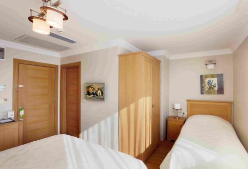 a bedroom with a bed and a wooden cabinet at Hotel Expocity Istanbul in Avcılar