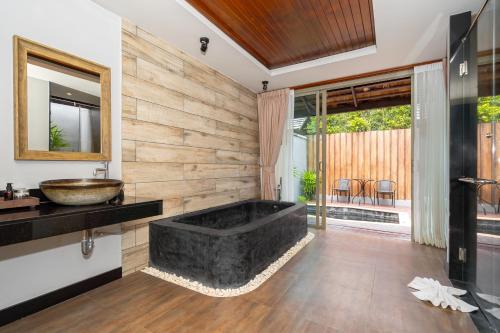 a bathroom with a large tub and a sink at Malabar Pool Villa Phuket in Phuket Town