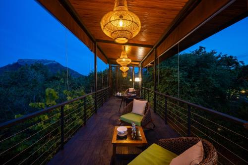 a balcony of a resort with chairs and a table at Roo Mansala Boutique Villas in Sigiriya