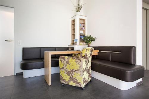 a room with a bench and a table and a chair at Taome Feng Shui Stadthotel Breisgau in Emmendingen