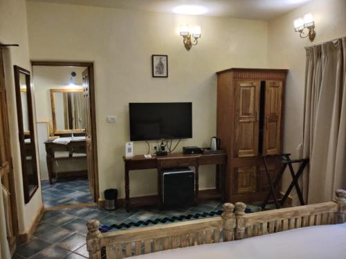 a living room with a television and a room with at Amritara Aura Resort & Spa in Mandrem