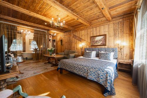 a bedroom with a bed and a room with a tub at Boutique Hotel Virkas muiža in Kuldīga