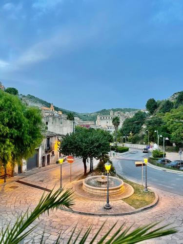 a street with a fountain in the middle of a city at Moronero in Ragusa