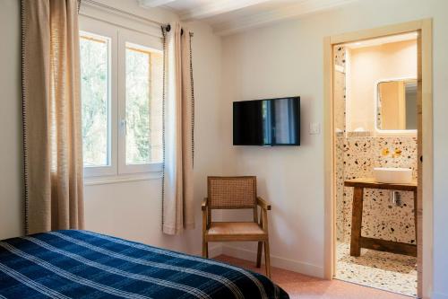 a bedroom with a bed and a chair and a mirror at Domaine La Gentilhommière in Satillieu