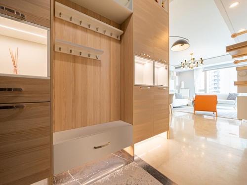 eine Küche mit Holzschränken und einem orangefarbenen Stuhl in der Unterkunft iHome-Lujiazui Riverside, Shanghai's Leading Advocate for Genuine Apart ment - Committed to Quality, Bund RiverView&CityWalk, Deluxe Neighborhood in Shanghai