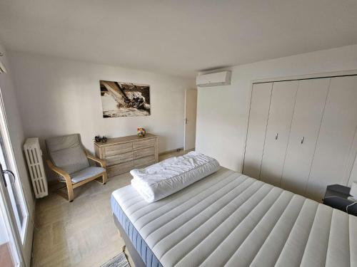 une petite chambre avec un lit et une chaise dans l'établissement Bel appartement, 6 couchages, WIFI, climatisé, parking, 10 minutes à pied de la mer, à Sanary-sur-Mer