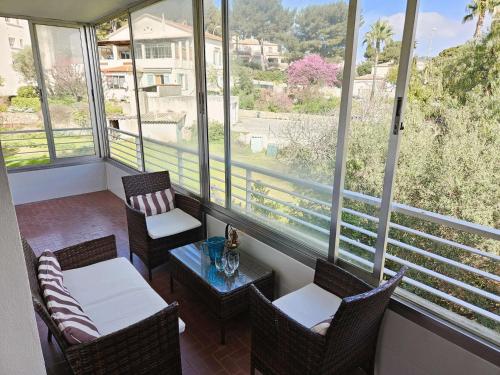 d'un balcon avec des chaises, une table et des fenêtres. dans l'établissement Bel appartement, 6 couchages, WIFI, climatisé, parking, 10 minutes à pied de la mer, à Sanary-sur-Mer