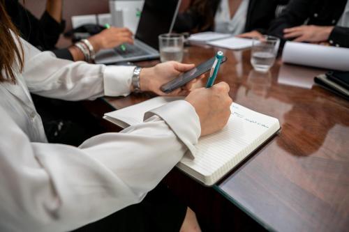 Un groupe de personnes assises à une table utilisant un téléphone portable dans l'établissement WS St Germain - Quartier Latin, à Paris