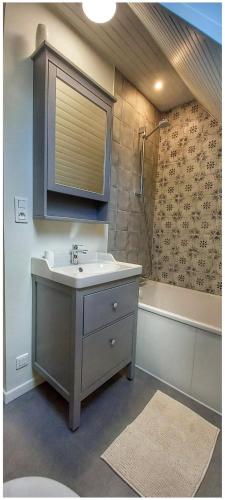 une salle de bain avec un lavabo et une baignoire dans l'établissement Maison bretonne entre terre et mer, à Crozon