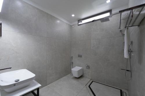 a bathroom with a toilet and a sink and a shower at EVE Nest in Edappally