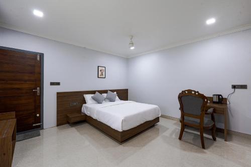 a bedroom with a bed and a desk and a chair at EVE Nest in Edappally
