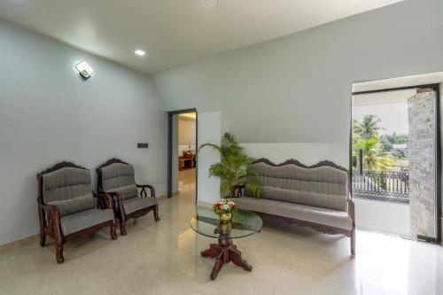 a living room with two couches and a glass table at EVE Nest in Edappally