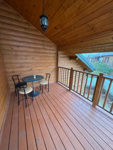 a room with a table and chairs on a wooden deck at Arnika in Skhidnitsa