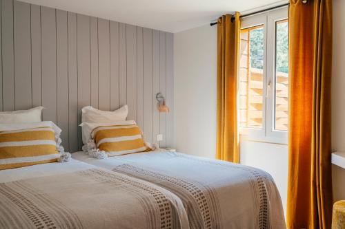 a bedroom with a bed with orange curtains and a window at Domaine La Gentilhommière in Satillieu