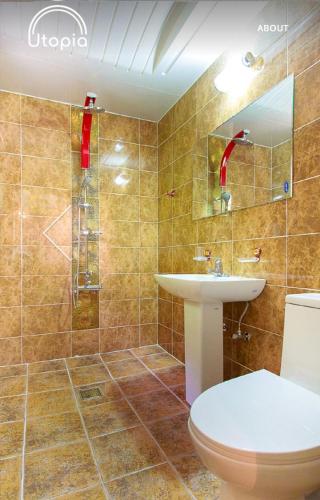 a bathroom with a toilet and a sink and a shower at Utopia Pension in Gyeongju