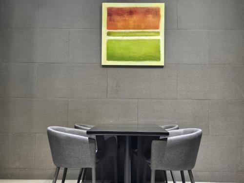 a black table with chairs and a painting on a wall at Rivertain Hotel Gyeongju in Gyeongju