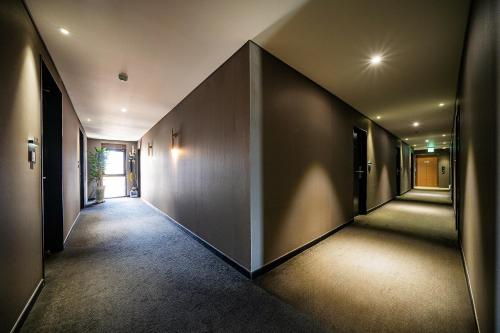 an empty hallway with dark walls and a large wall at Rivertain Hotel Gyeongju in Gyeongju