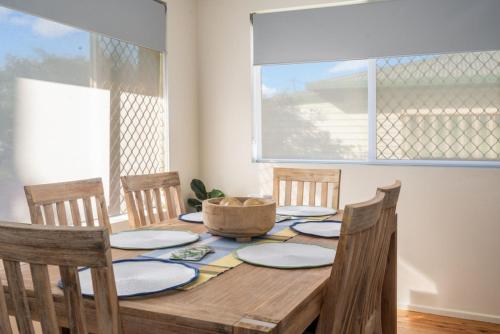 a dining room table with chairs and a window at Sasta Nambucca in Nambucca Heads