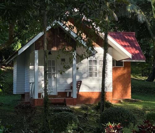a small white house with a red roof at Pansand Resort in Ko Bulon Le