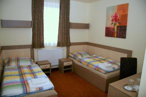 a small room with two beds and a window at Imet Centrum in Bratislava