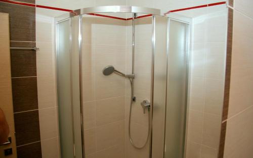ブラチスラヴァにあるImet Centrumの赤いラインの天井のバスルーム(シャワー付)