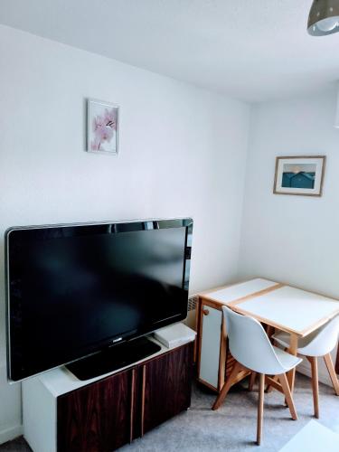 un salon avec une grande télévision et une table dans l'établissement Appart Deauville Villers, à Villers-sur-Mer