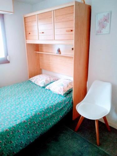 une petite chambre avec un lit et une chaise dans l'établissement Appart Deauville Villers, à Villers-sur-Mer