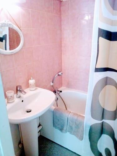 - une salle de bains rose avec lavabo et baignoire dans l'établissement Appart Deauville Villers, à Villers-sur-Mer