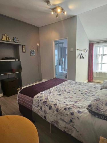 a bedroom with a large bed and a bathroom at The Ship Hotel in Crediton