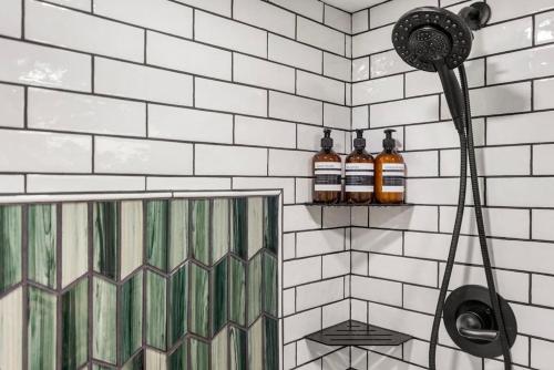 a bathroom with a shower with two bottles on the wall at Cute West Seattle Home w Firepit in Seattle