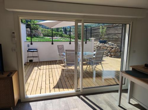 a sliding glass door leading to a patio with a table and chairs at Studio indépendant climatisé in Pégomas