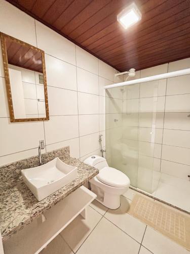 a bathroom with a sink and a toilet and a mirror at Maré in Morro de São Paulo