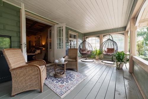 a screened in porch with chairs and a table at Boutique Hotel Virkas muiža in Kuldīga