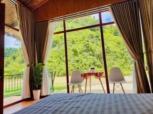 Un dormitorio con una cama y una mesa y sillas. en Cát Lý Camping homestay, en Ha Giang