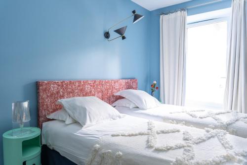 two beds in a bedroom with blue walls at Domaine La Gentilhommière in Satillieu