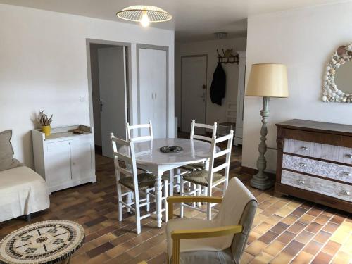 un salon avec une table et des chaises de salle à manger dans l'établissement Appartement T3, avec terrasse, place de parking privée, à Saintes-Maries-de-la-Mer