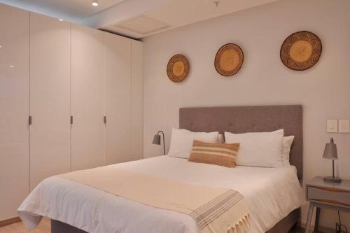 开普敦Eagles Eye, Aestetic escape with panoramic views的卧室里有一张床，墙上挂着两个钟