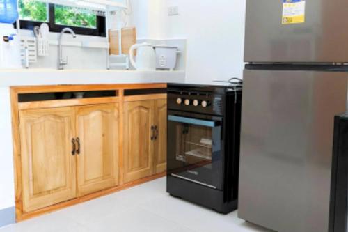 a kitchen with a black stove and a refrigerator at Ormoc City Gate 3 in Ormoc