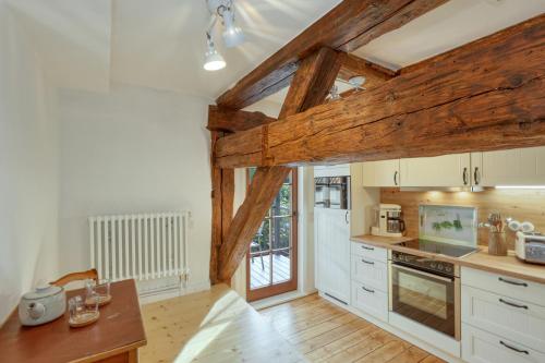 a kitchen with white cabinets and wooden beams at Ferienwohnungen Steinweg 61 in Quedlinburg