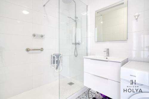 une salle de bain blanche avec un lavabo et une douche dans l'établissement Le Panoramique- Vue Tour Eiffel - 313B, à Paris
