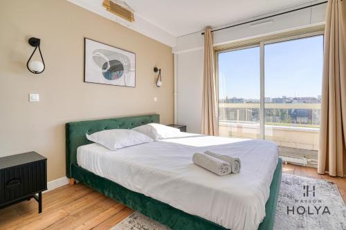 une chambre avec un lit et une grande fenêtre dans l'établissement Le Panoramique- Vue Tour Eiffel - 313B, à Paris