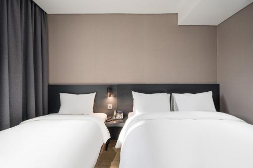 two beds sitting next to each other in a hotel room at Rivertain Hotel Gyeongju in Gyeongju