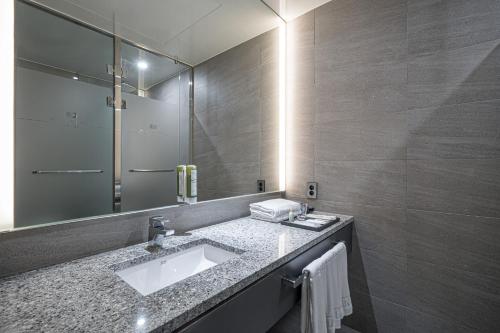 a bathroom with a sink and a mirror at Rivertain Hotel Gyeongju in Gyeongju