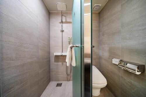 a bathroom with a toilet and a glass shower door at Rivertain Hotel Gyeongju in Gyeongju