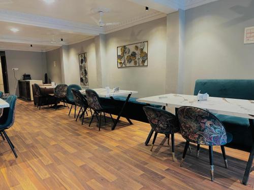 a room with tables and chairs in a room at Hotel Royal Palm Inn in Faizābād