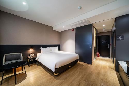 a bedroom with a bed and a chair and a desk at Rivertain Hotel Gyeongju in Gyeongju