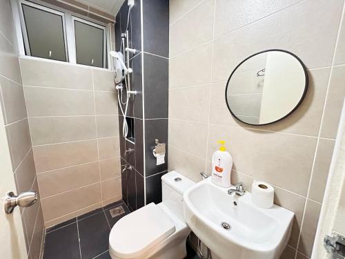 a bathroom with a toilet and a sink and a mirror at Kulai d putra suites beside ioiMall near JPO and Airport in Kulai