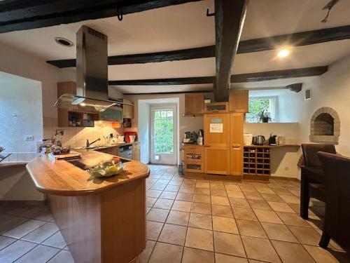 une grande cuisine avec un îlot au milieu dans l'établissement Le Moulin d'Hagenthal, à Hagenthal-le-Bas