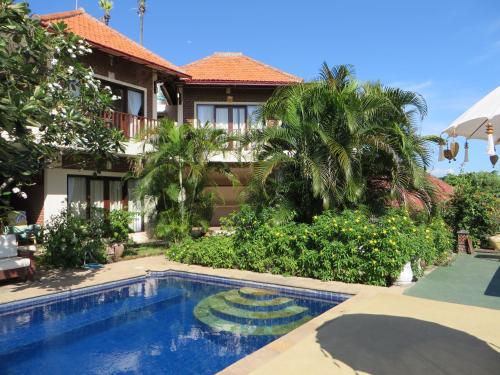 a villa with a swimming pool in front of a house at Jukung Dive Resort Bali AMED in Amed